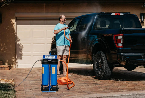 Man using Deionized Water System For Cars, RVs, Boats, Planes And More, Spotless Wash Experience on black truck in driveway