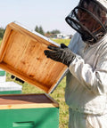 Beekeeper inspecting top cover of Beekeeping Beehive 3-Piece Parts Kit With Top Cover, Inner Cover, And Bottom Board, 10-Frame Solid Wood Beeswax Finish