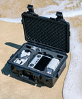 Open waterproof hard case for DJI Mini 4 Pro Mini 3 Pro and RC transmitters RC 2 RC N2 N1 with foam padding on sandy beach
