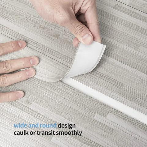Hands peeling back Self Adhesive Vinyl Floor Transition Strip For Laminate And Tile Floors Easy Peel And Stick Flat Floor Divider Carpet Threshold Ten Feet Long One Point Five Seven Inches Wide White Washed