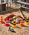 Mini traffic cones bulk pack in assorted colors beside bricks and construction site, designed for model layouts or events.