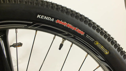 Close-up of Salire SJ-50 Dirt Jumper Bike With Disc Brakes And 26 Inch Wheels showing small block tires and double walled rims.
