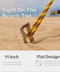 Six Pack 11 Inch Stainless Steel Tent Stakes For Camping Gear Heavy Duty Ground Anchors in sand with rope attached.