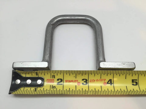 Metal D-ring clip for cable management beside a measuring tape, not the 2 Inch Distribution Rings 25 Pack For Cable Management.