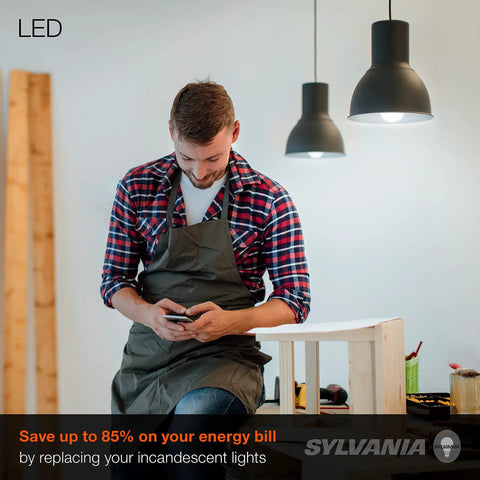 Man using phone under hanging lights, promoting "Brighten Everyday With Energy Saver LED A19 Bulbs 60W Equivalent, 800 Lumens, Frosted Finish"