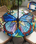 Butterfly Pattern Round Outdoor Tablecloth With Umbrella Hole And Zipper on a 45-53 inch patio table, in garden setting.