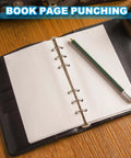 Open notebook with grid paper and pencil, showcasing book page punching feature for 1/4 Inch Single Hole Punch Kit, 12 Pack Handheld Metal Paper Puncher