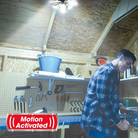 Motion Activated Garage Light With 96 Ultra Bright LEDs, 6000 Lumens, illuminating a workshop with a person working.