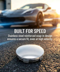 Crank Up Your Ride With These Sweet 4 Pack Silver Wheel Center Caps That Snap Right On Cars Trucks Or Suv With A Rock Solid Grip 60Mm Size And Built Different Materials To Keep Your Setup Looking Clean All Season Long, showing a sleek, stainless steel center cap on asphalt.