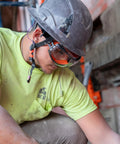 Worker wearing APEX Safety Goggles ANSI Z87 Anti Fog Eyewear with Adjustable Head Strap, hard hat on industrial construction site