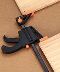 Close-up of 4 Inch Bar Clamps For Woodworking 5 Piece Trigger Quick Grip Clamps with One Handed Ratchet holding wood pieces.