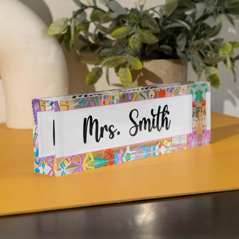 Customizable Teacher Desk Name Plate In 12 Designs And 9 Fonts, Available In 2 Sizes, Acrylic Office Name Plate Gift For Teachers, Personalize With Name And Title For Any Classroom with decorative border, displaying 'Mrs. Smith'. Acrylic material on desk.
