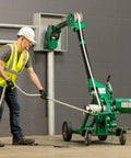 Man operating Greenlee 10k Tugger Package Featuring Dual Speed Motor For Faster Pulls with footswitch in safety gear.