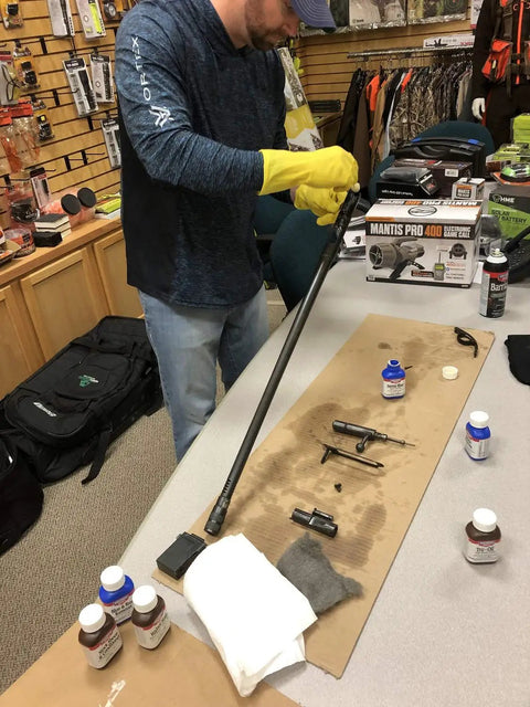 Person cleaning rifle parts using Gun Scrubber Cleaner 15-Ounce Aerosol For Fast Evaporating, Deep Cleaning Of Metal Firearm Parts