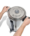 Person holding 100 Cup Coffee Urn And Hot Beverage Dispenser With Dripless Faucet, Quick Brew For Big Batches, Stainless Steel Warmer