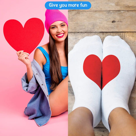 Woman holding red heart shape with feet in white socks featuring heart design on wooden floor
