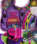 Unicorn Party Playset With 25 Surprises showing purple castle with rainbow and sun details, part of portable mini set for castle adventure.
