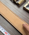 Close-up of leather piece stitched with Pro Grade Leather Pricking Irons And Diamond Stitching Chisel Set, ruler nearby.