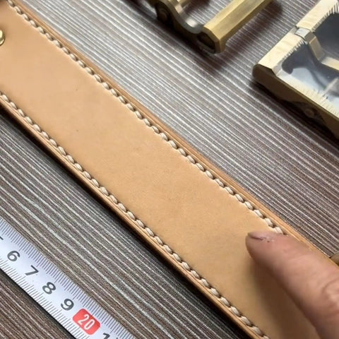 Close-up of leather piece stitched with Pro Grade Leather Pricking Irons And Diamond Stitching Chisel Set, ruler nearby.