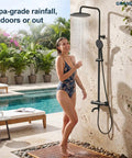 Woman enjoying the GRANDJOY Exposed Tub and Shower System with Handheld Spray, Matte Black, outdoors under rainfall shower.