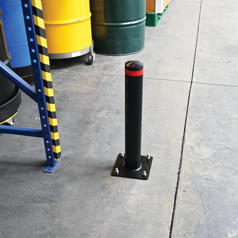 Badass 24 Inch Steel Garage Safety Bollard Wall Defender Pipe Guard With Pre Drilled Mounting Holes Matte Black Finish standing in a warehouse.