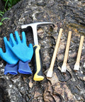 Geology Rock Hammer Kit For Rock Hounding And Prospecting includes rock hammer, chisels, and gloves on rock surface.