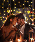 Heart Curtain Lights For Valentine's Day And Romantic Room Vibes USB Plug Or Battery Powered 123 LED 11 Heart Light Up String Lights In Warm White Ideal Window Bedroom Closet Wall Decor hanging with couple under them.
