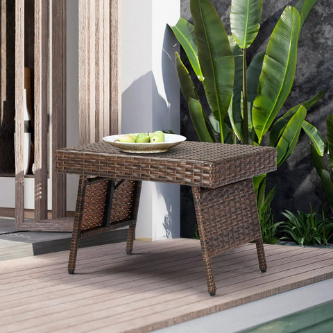 Portable Folding Wicker Table With Steel Frame For Outdoor Use next to poolside with green plants