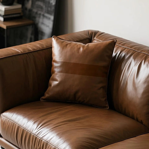 Brown leather sofa with cushion, showcasing Leather Repair Tape Self Adhesive Patch Kit 3x60 Inches Black For Furniture use.