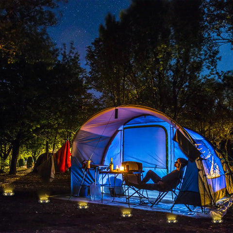 12 Pack Solar Lights Outdoor Waterproof Ground Landscape Lighting illuminating campsite with tent and chairs at night.