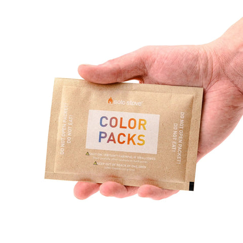 Hand holding a single packet of Color Changing Fire Packets For Fire Pit Ten Pack Of Colorful Flames For Outdoor Pits