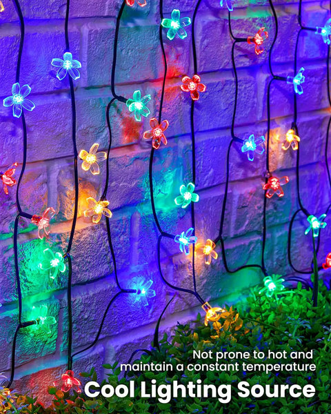 60 LED Cherry Blossom Solar String Lights Outdoor Waterproof Fairy Lights For Garden Yard Fence Patio Christmas Tree Wedding Party Decor Multicolor glowing against brick wall.