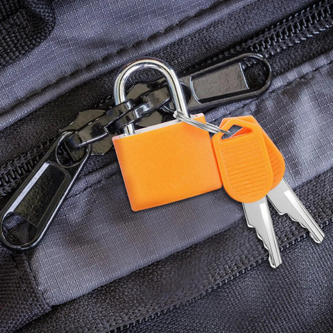 Orange small metal padlock with plastic covered copper keyed mechanism on a black zipper, part of Six Pack Multicolor Mini Luggage Locks With Keys For Lockers And Suitcases.