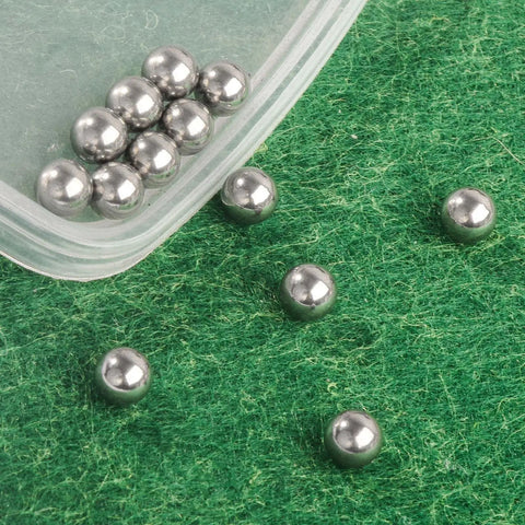 120 Pieces 6mm Stainless Steel Bearing Balls for Bicycle Maintenance and Repairs on green surface, close-up view