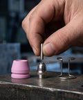 Hand holding nozzle tip above Plasma Torch Consumables One Set With Nozzle Tip And Electrodes For Pro Grade Precision Cutting And Welding Accessories Durable Replacement Parts For Air Plasma Cutter