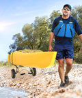 Man transporting yellow kayak on Go-To Universal Kayak Carrier Trolley For Kayaks Canoes Paddleboards Float Mats And Jon Boats With 200-Pound Capacity, Solid Airless Tires, Anodized Aluminum Frame, Easy Handle, And Two Ratchet Straps along rocky shore.
