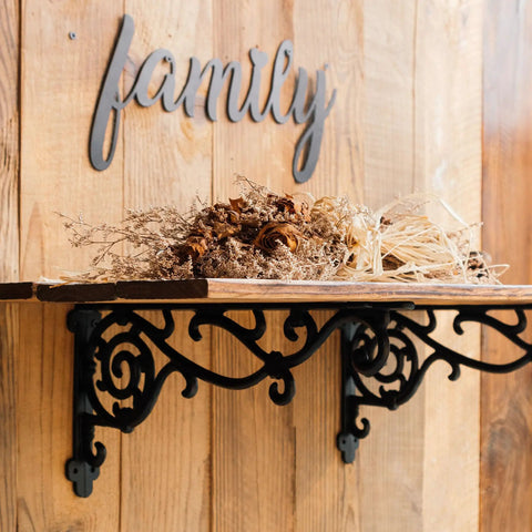 Rock Solid Decorative Shelf Brackets Wrought Iron Corbels 15.5 X 7.2 In Antique Black holding dried flowers on wooden shelf.