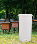 Two-Frame Manual Honey Extractor for Beekeeping, Durable Plastic Centrifuge Tool, White, Easy Grip S-Shaped Handle, Ideal for Home or Store Honey Harvesting, 15.75 by 28.35 Inches, beside beehives