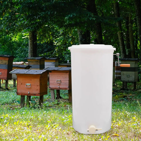 Two-Frame Manual Honey Extractor for Beekeeping, Durable Plastic Centrifuge Tool, White, Easy Grip S-Shaped Handle, Ideal for Home or Store Honey Harvesting, 15.75 by 28.35 Inches, beside beehives