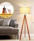 Wood Tripod Floor Lamp With Mid Century Vibe in living room, tall standing lamp with flaxen linen shade and pull chain switch