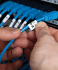 Applying Rhino Industrial Flexible Nylon Labels Three Quarters Inch By Eleven Point Five Foot Black Print On White Tape to blue cable.