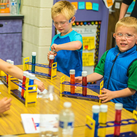 Children using Large Plastic Test Tubes and Rack Set With Six Bottles Kid Friendly Science Experiments Durable Clear Lab Kit For Classroom Fun and Home STEM Projects For Hands On Learning in a classroom.