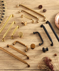 Variety of cabinet pulls, including Antique Brass Zinc Alloy Cabinet Pulls 3 Inch Hole Center 76mm, on wooden surface.
