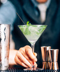 Bartender holding cocktail with Skinny Black Plastic Sip Stirrer Straws For Coffee And Cocktails, Seven And A Half Inch Stirrers