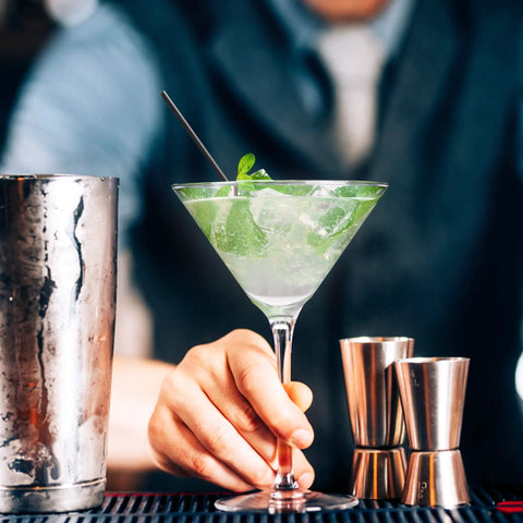 Bartender holding cocktail with Skinny Black Plastic Sip Stirrer Straws For Coffee And Cocktails, Seven And A Half Inch Stirrers