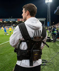 Man wearing Thanos X Gimbal Support Vest System Steadicam Rig for DJI RS4 Pro RS3 RS2 With V Mount Battery and Transmitter at sports event
