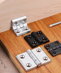 Zinc Alloy Mini Folding Hinges For Cabinets 44mm By 63mm Black 180 Degree Adjustable Hinges displayed on wooden board with tools