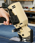 Gearpass 250W Electric Fabric Cutter With Extra 4-Inch Rotary Blade And Auto Sharpener handheld machine cutting through denim.