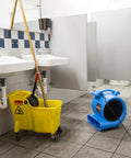One Half Horsepower Heavy Duty Air Mover, Lightweight Carpet Dryer and Floor Blower in a restroom next to a mop bucket