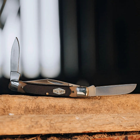 Solid As A Rock Pocket Folder With 2 Inch Clip Point Blade Crafted From High Carbon Stainless Steel And Rough Cut Sawcut Grip on wood.